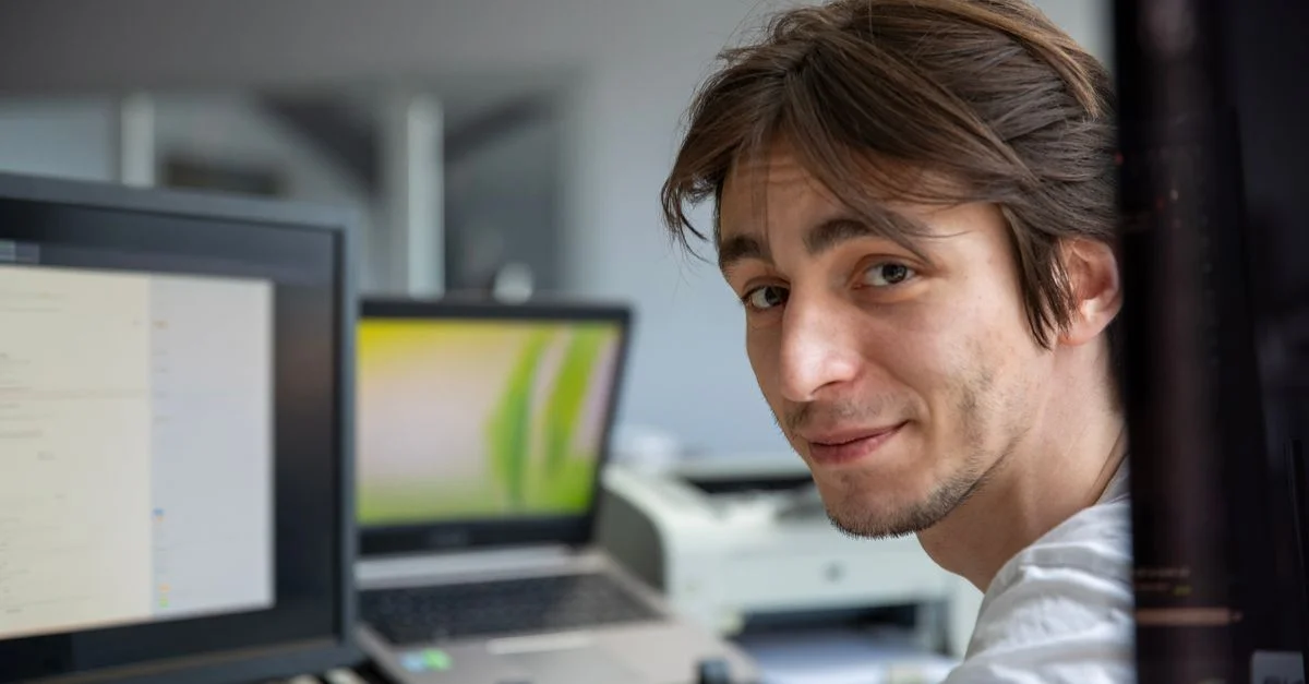 Un jeune professionnel travaillant à son bureau dans un environnement de bureau moderne.