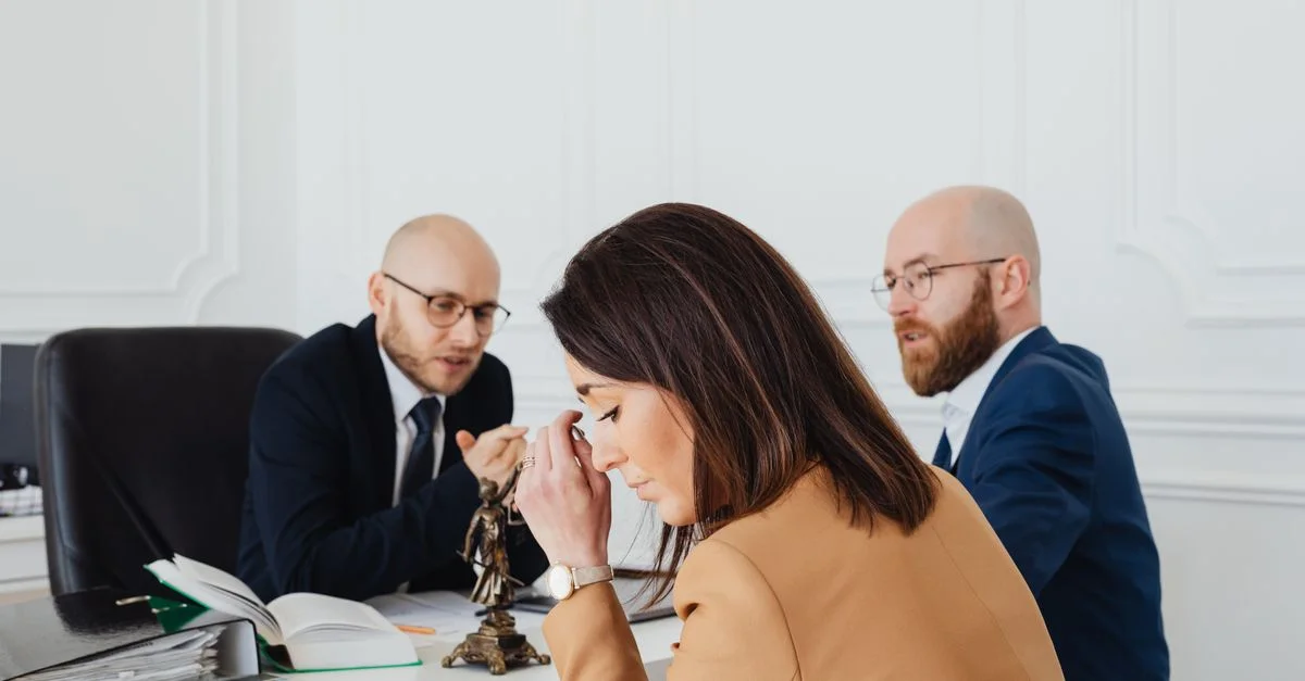 Une discussion tendue entre avocats et un client dans un cadre de bureau.